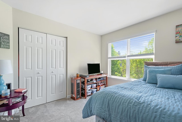 bedroom featuring light colored carpet and a closet