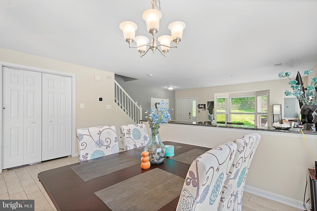 dining room featuring stairs, a notable chandelier, visible vents, and light wood-style floors