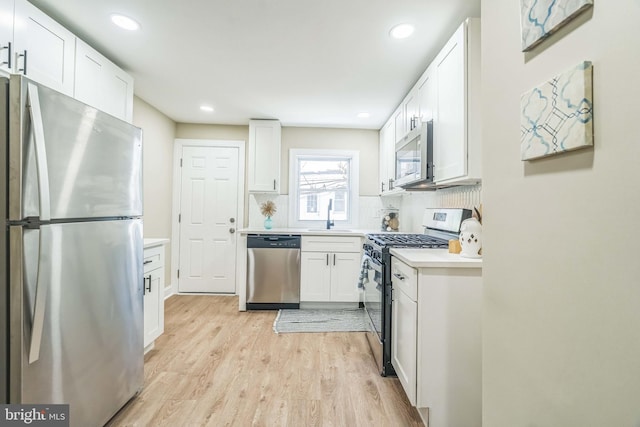 226 N 64th St, Philadelphia, PA 19139 - kitchen featuring a sink, light countertops, light wood-style flooring, stainless steel appliances, and white cabinetry