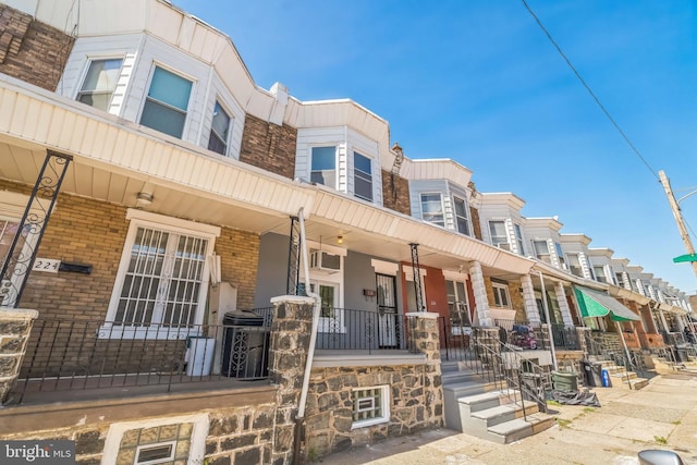 226 N 64th St, Philadelphia, PA 19139 - view of front facade featuring a residential view, covered porch, a wall mounted AC, and stone siding