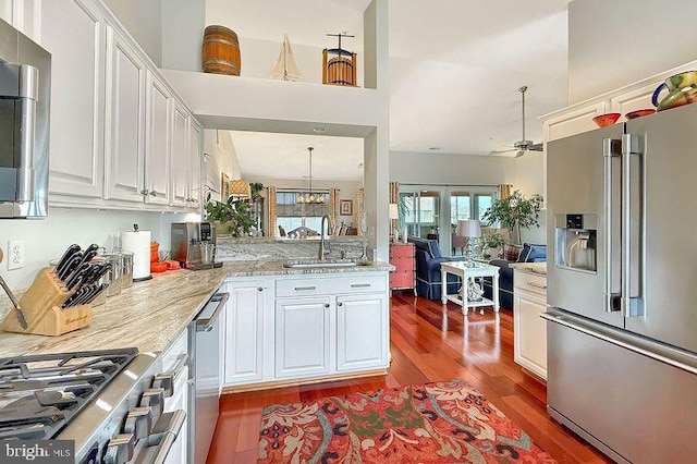 kitchen featuring a sink, white cabinetry, wood finished floors, and high quality appliances