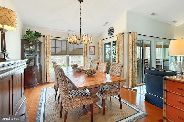 dining room featuring a notable chandelier, visible vents, and light wood-type flooring