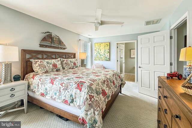 bedroom featuring ceiling fan, light colored carpet, and visible vents