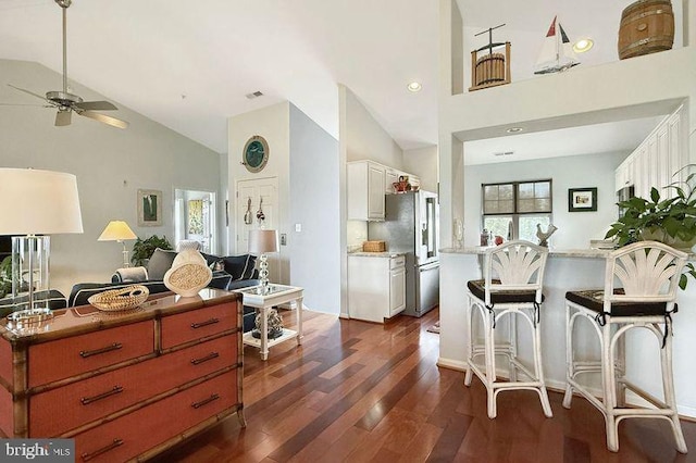 interior space with high vaulted ceiling, a ceiling fan, dark wood-style flooring, and high end fridge
