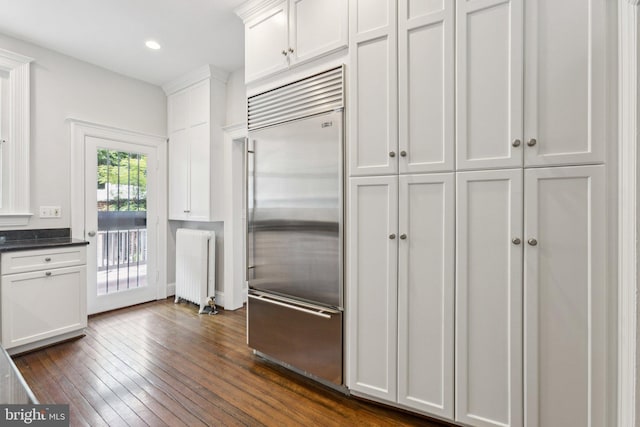 1847 Lamont St NW, Washington, DC 20010 - kitchen with stainless steel built in fridge, dark wood-style flooring, white cabinets, radiator, and recessed lighting