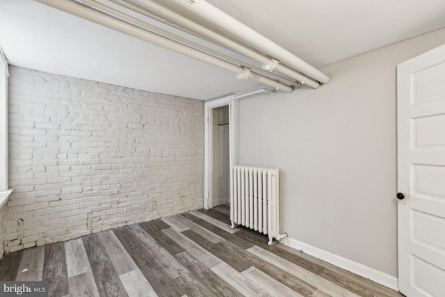 1847 Lamont St NW, Washington, DC 20010 - finished below grade area featuring radiator heating unit, brick wall, and wood finished floors
