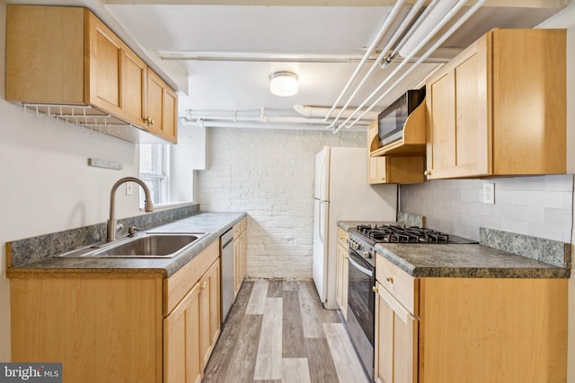 1847 Lamont St NW, Washington, DC 20010 - kitchen featuring stainless steel appliances, light wood-style flooring, dark countertops, decorative backsplash, and brick wall