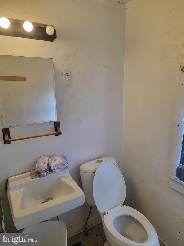 half bath with toilet and a sink