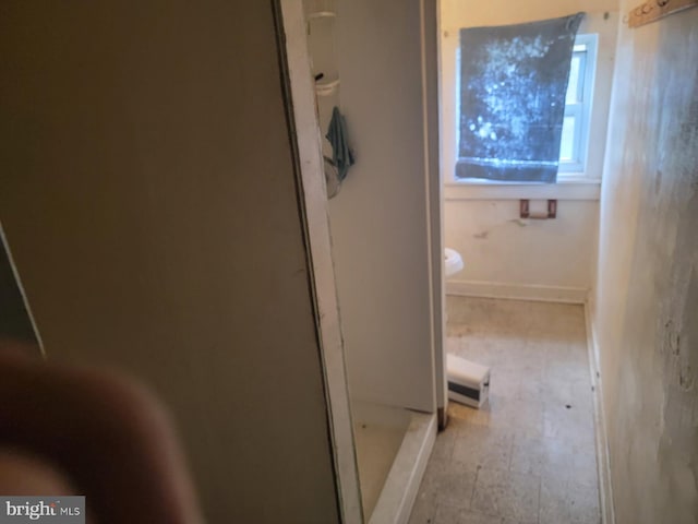 full bath featuring a stall shower and toilet