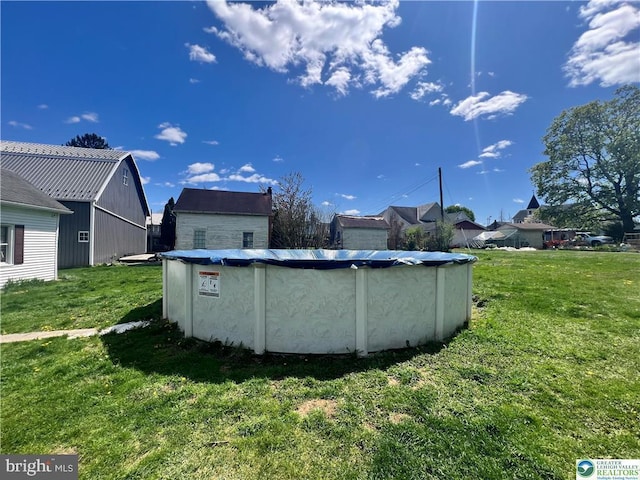 view of pool with a covered pool and a lawn