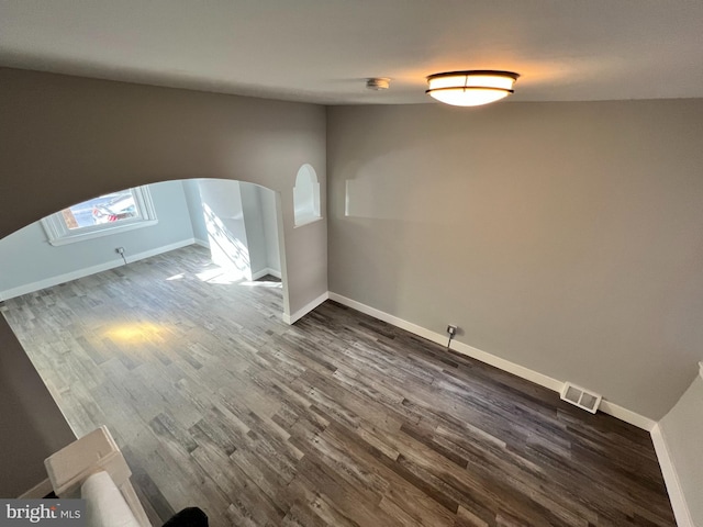 2109 E Tioga St, Philadelphia, PA 19134 - empty room featuring arched walkways, dark wood-style floors, and baseboards