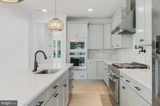 4763 Williamsburg Blvd, Arlington, VA 22207 - kitchen featuring appliances with stainless steel finishes, a sink, exhaust hood, backsplash, and hanging light fixtures