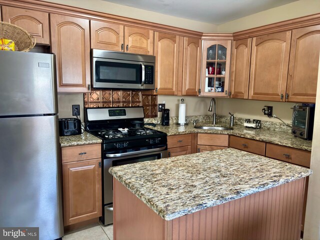113 Lexington Dr, Tuckerton, NJ 08087 - kitchen featuring appliances with stainless steel finishes, a sink, light stone counters, glass insert cabinets, and a kitchen island