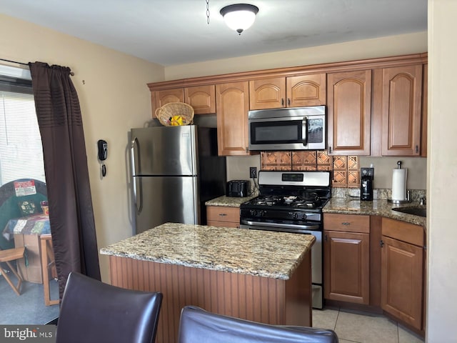 113 Lexington Dr, Tuckerton, NJ 08087 - kitchen with stainless steel appliances, a kitchen island, light stone countertops, brown cabinetry, and tasteful backsplash