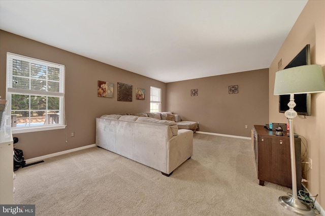 living area with light carpet, baseboards, and visible vents