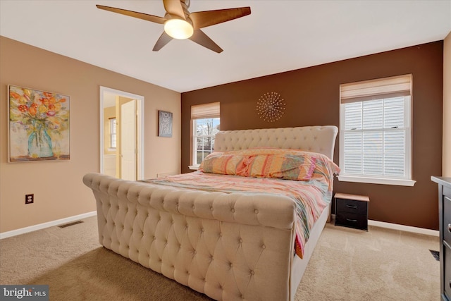 carpeted bedroom featuring baseboards, a ceiling fan, and visible vents