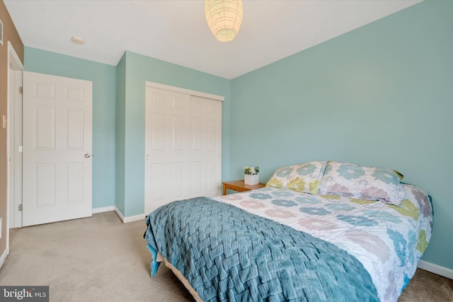 carpeted bedroom with baseboards and a closet