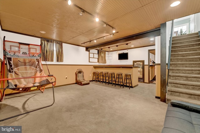 unfurnished room featuring a bar, stairs, carpet flooring, and track lighting