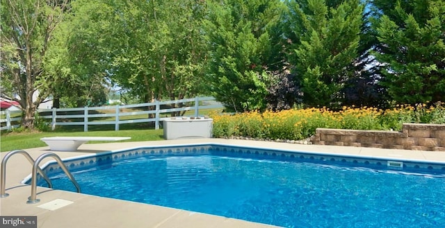 view of swimming pool featuring a diving board, fence, and a fenced in pool