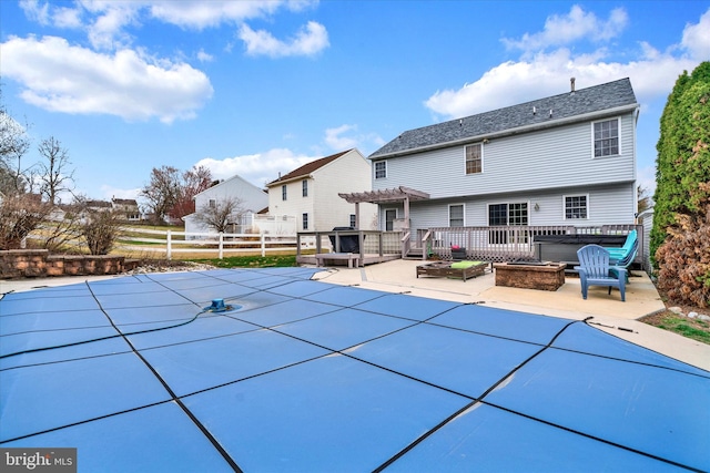 view of swimming pool featuring fence, a patio area, a covered pool, a pergola, and a wooden deck