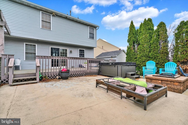 view of patio / terrace with a hot tub, an outdoor fire pit, and a wooden deck