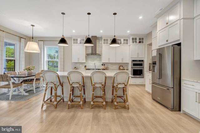 40928 Arcadian Pond Ct, Aldie, VA 20105 - kitchen featuring appliances with stainless steel finishes, wall chimney exhaust hood, decorative backsplash, light wood-style flooring, and recessed lighting