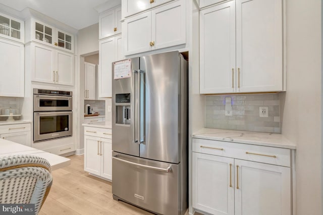40928 Arcadian Pond Ct, Aldie, VA 20105 - kitchen featuring appliances with stainless steel finishes, decorative backsplash, white cabinetry, light wood finished floors, and glass insert cabinets