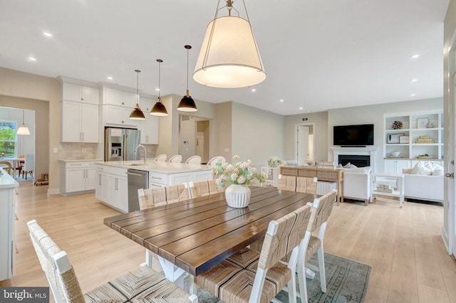 40928 Arcadian Pond Ct, Aldie, VA 20105 - dining space featuring a fireplace, light wood-style flooring, and recessed lighting