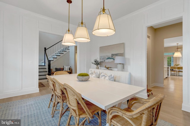 40928 Arcadian Pond Ct, Aldie, VA 20105 - dining area featuring stairs, light wood finished floors, a decorative wall, and baseboards