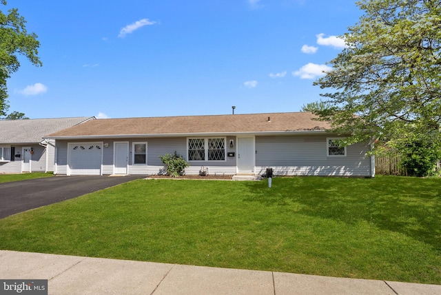 ranch-style house with a front yard, fence, aphalt driveway, an attached garage, and entry steps