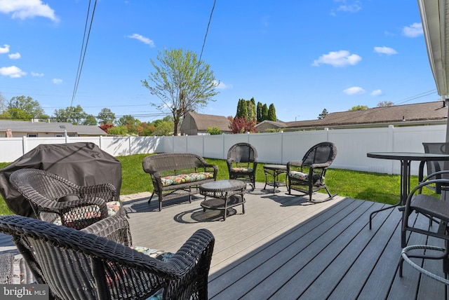 wooden terrace with a fenced backyard, an outdoor living space, and a yard