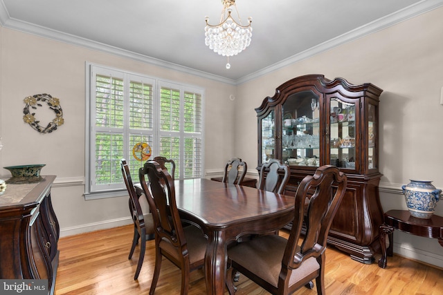 dining area featuring baseboards, light wood finished floors, crown molding, and a notable chandelier