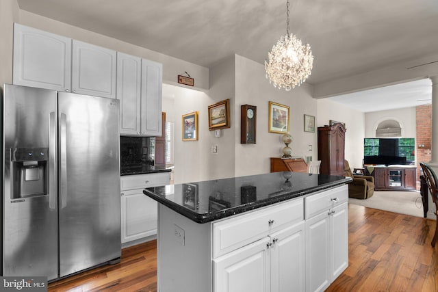 kitchen featuring an inviting chandelier, stainless steel fridge with ice dispenser, a center island, white cabinetry, and wood finished floors
