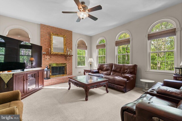 living area with carpet floors, a ceiling fan, and a fireplace