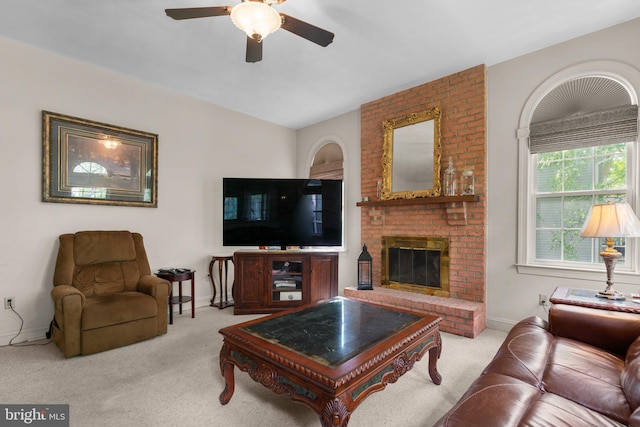 carpeted living area featuring baseboards, a ceiling fan, and a brick fireplace