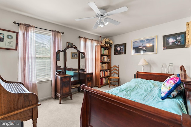 bedroom with a ceiling fan, baseboards, and light carpet