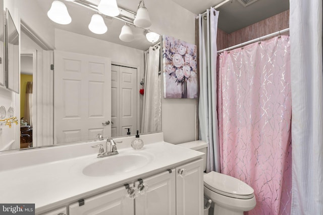 bathroom featuring toilet, a shower with curtain, visible vents, and vanity
