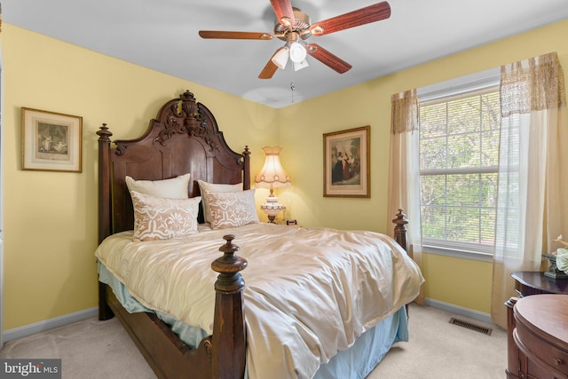 bedroom with light colored carpet, baseboards, visible vents, and a ceiling fan