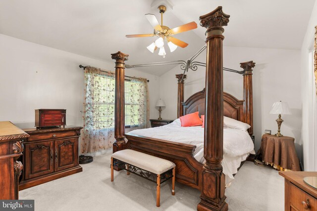 bedroom with a ceiling fan, vaulted ceiling, and light carpet