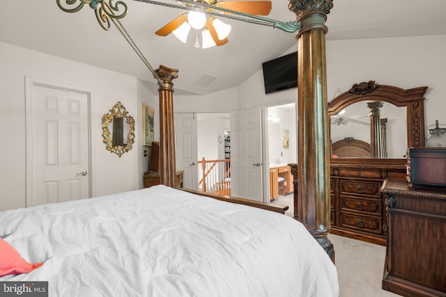 bedroom featuring a ceiling fan, ornate columns, carpet flooring, ensuite bath, and vaulted ceiling