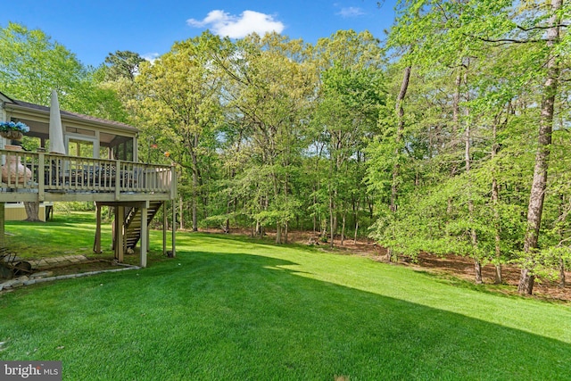 view of yard with stairway, a deck, and a sunroom