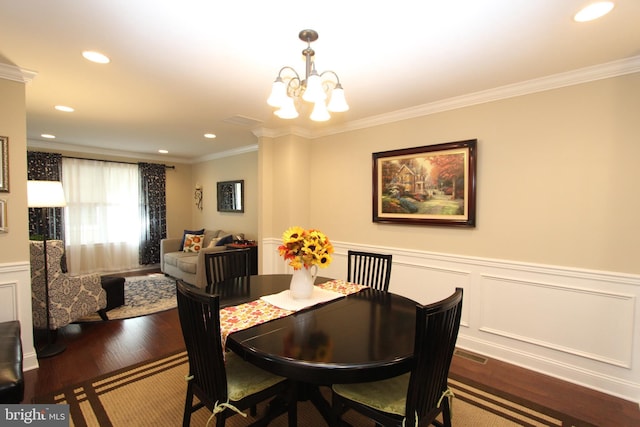 dining room with ornamental molding, dark wood-style floors, recessed lighting, a wainscoted wall, and a notable chandelier