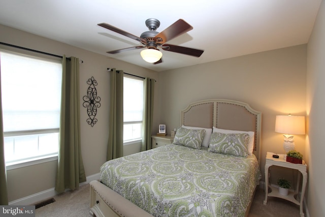 bedroom featuring baseboards, light carpet, a ceiling fan, and visible vents