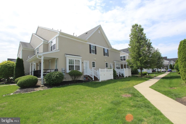 view of side of home with a yard and covered porch