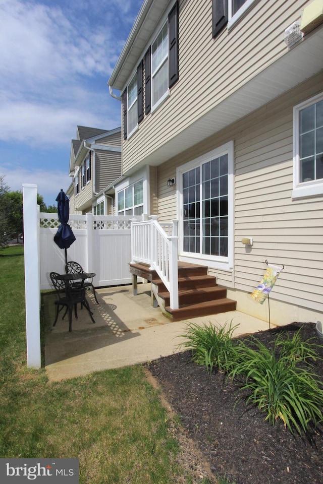 entrance to property with a patio area and fence