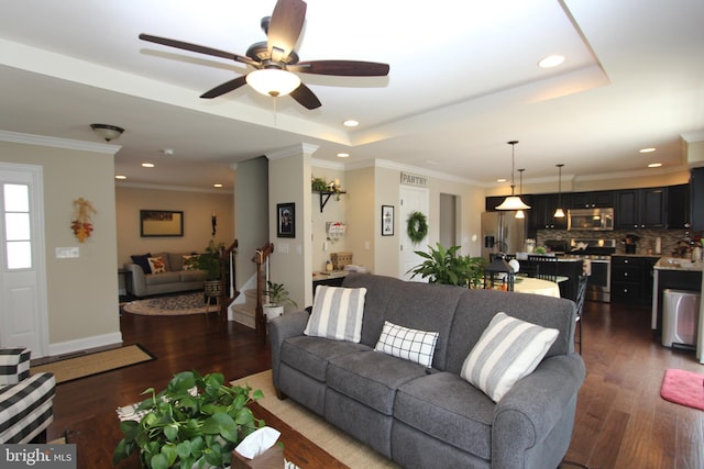 living area with recessed lighting, a ceiling fan, a raised ceiling, and wood finished floors