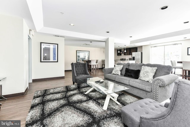 living room featuring baseboards, recessed lighting, wood finished floors, and visible vents