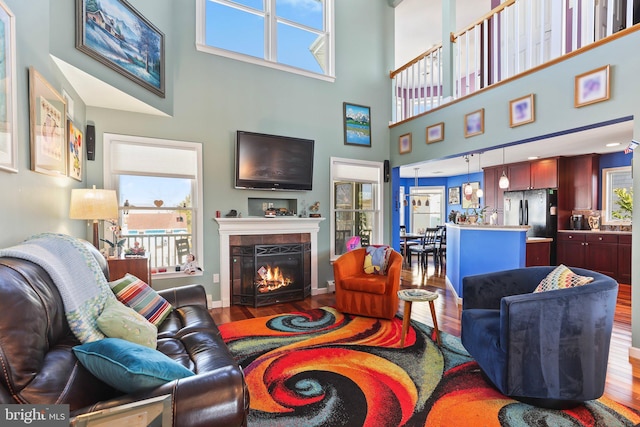 1511 Barnegat Ave, Ship Bottom, NJ 08008 - living area featuring baseboards, a tiled fireplace, wood finished floors, and a towering ceiling