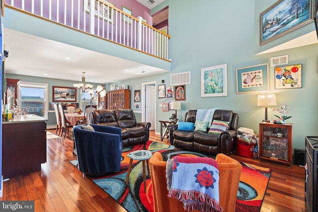1511 Barnegat Ave, Ship Bottom, NJ 08008 - living room with visible vents, a towering ceiling, hardwood / wood-style floors, and an inviting chandelier