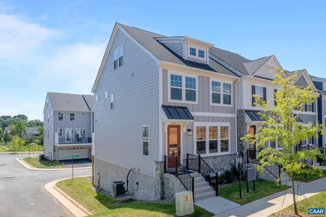 view of front facade featuring central AC unit, board and batten siding, metal roof, and a standing seam roof